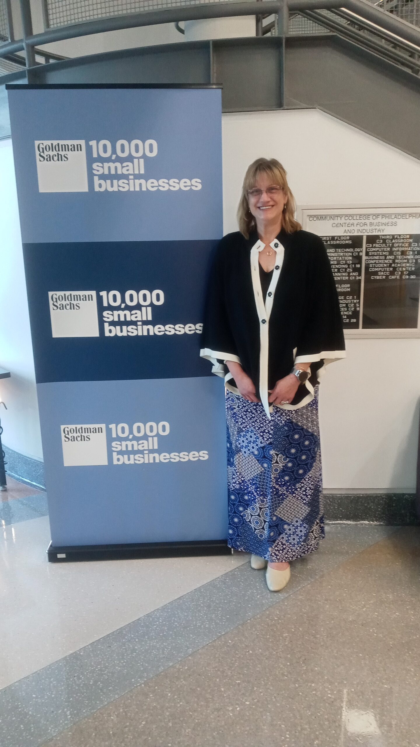 Abigail Mirarchi, Founder, and Managing Director stands in front of GS10KSB sign